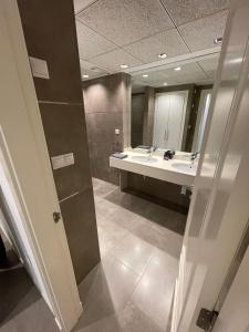 a bathroom with two sinks and a large mirror at PRIMERA LINEA PLAYA PATACONA, VALENCIA in Valencia