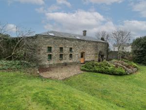 an old stone house with a garden in front of it at The Coach House in Abergavenny
