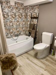 a bathroom with a white tub and a toilet at Ski Chalet Rinerhorn in Glaris