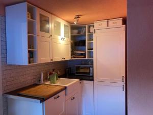a white kitchen with white cabinets and a sink at Ski Chalet Rinerhorn in Glaris +5 photos