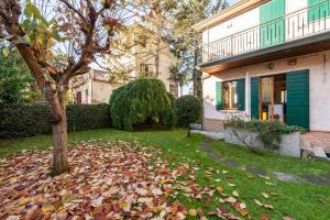 a yard with leaves on the ground in front of a house at Cozy 2-Bedroom Stay at Lido di Venezia in Lido