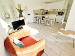 een woonkamer met een bank en een keuken bij Le Piade, confort moderne, vue dégagée, clim, ascenseur, WiFi in Sète