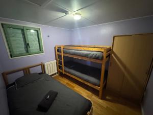 una habitación con dos literas y una ventana en La petite condemine, en Beaumont-sur-Grosne