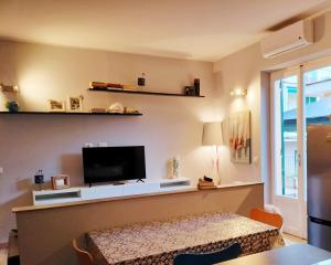 Una sala de estar con un televisor de pantalla plana en una pared. en rubino home, en Sestri Levante