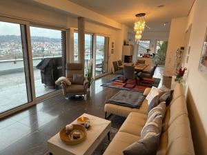 a living room with a couch and a table at Ferienwohnung - Penthauswohnung Albblick, traumhafter Ausblick, ruhige Lage in Balingen