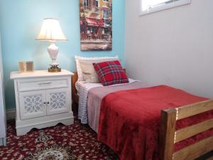 波士顿BlueJay Room的卧室里有一张床和一张带灯的桌子