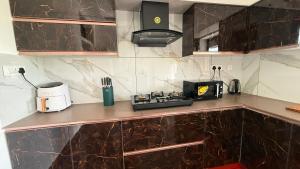 a kitchen with a counter with a toaster and a microwave at Leafy Mist Villa in Munnar