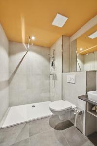 a bathroom with a shower and a toilet and a sink at Hotel Bad Dürkheim in Bad Dürkheim