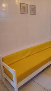 un banc jaune et blanc dans une pièce dans l'établissement Ap em Balneário Camboriú, à Balneário Camboriú