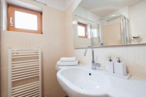 een witte badkamer met een wastafel en een spiegel bij Center Brela Apartment in Brela +2 foto's