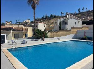 a large blue swimming pool in front of some buildings at Olé studio Apartment in Rojales