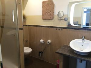 a bathroom with a sink and a toilet at Hotel Sandmanns am Dom in Cologne