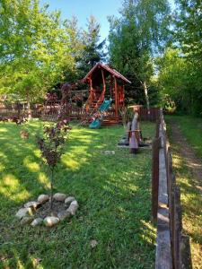 a park with a playground with a tree in the grass at Gergely Attila Vendégház in Izvoare