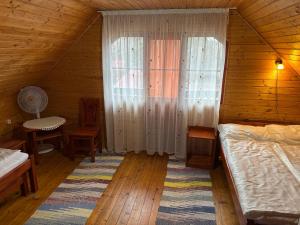a bedroom with a bed and a table and a window at Gergely Attila Vendégház in Izvoare +31 photos