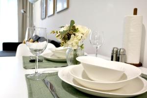 a table with white plates and wine glasses on it at DUTTI'S HOME - 1 Zimmer Apartment, Küche, Self-Check-in, Stellplatz in Ingolstadt