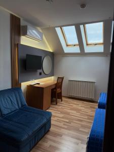 a room with a couch and a desk and a tv at Motel M Vlasenica in Vlasenica