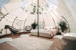 SuurerannaRanna Surfiküla的圆顶帐篷内的卧室,配有一张床和两块地毯
