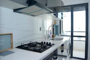 ケニトラにあるCopacabana Apartment - Sea Viewのコンロとシンクのあるキッチン +5枚の写真