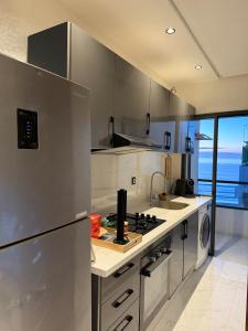 a kitchen with stainless steel appliances and a view of the ocean at Copacabana Apartment - Sea View in Kenitra