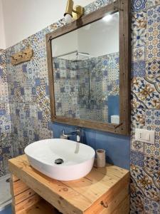 a bathroom with a white sink and a mirror at B&B Una favola di mare in Lampedusa +28 photos