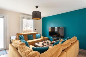 ein Wohnzimmer mit Sofa und Fernseher in der Unterkunft Chez Lisette - Maison climatisée dans Cancale in Cancale