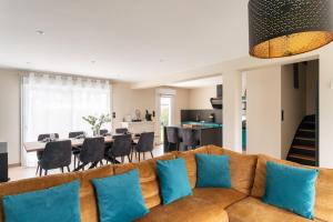 ein Wohnzimmer mit einer braunen Couch und blauen Kissen in der Unterkunft Chez Lisette - Maison climatisée dans Cancale in Cancale