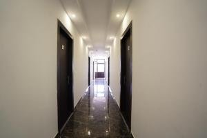 a corridor of a hallway with two doors and tile floors at Hotel Star Inn Opp Kalpna Chawla Civil Hospital Karnal, Kunjpura Road in Karnal