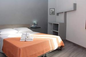 a bedroom with a bed with towels on a table at Osa rooms in Bosa