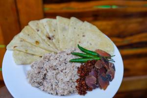 a plate of food with dip and nachos at Sun & Surf in Thulusdhoo