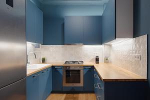 a kitchen with blue cabinets and a sink at Acropolis Classy Apartments in Athens +28 photos