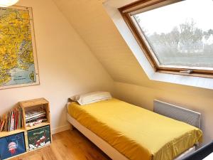 Un dormitorio pequeño con una cama y una ventana. en Maison lumineuse - Vue sur l'anse, en La Forêt-Fouesnant 6 fotos más