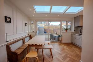 a kitchen with a table and chairs and a skylight at Wembley London lovely 6 bed House sleeps up to 14 in London