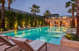 a swimming pool with chairs and palm trees at Four Seasons Hotel Casablanca in Casablanca
