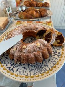 a bundt cake sitting on a plate with a knife at B&B Una favola di mare in Lampedusa