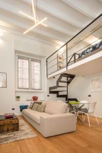 a living room with a white couch and a spiral staircase at Mgm Property - Wonderful Loft Tartaglia in Milan