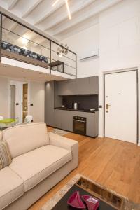 a living room with a couch and a kitchen at Mgm Property - Wonderful Loft Tartaglia in Milan