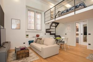 a living room with a white couch and a staircase at Mgm Property - Wonderful Loft Tartaglia in Milan