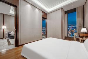 Postel nebo postele na pokoji v ubytování Roosevelt Service Apartment Chongqing Jiefangbei Pedestrian Street Hongyadong Branch