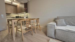 a living room with a table and chairs and a couch at Luxurious Vanilla Apartment, self check-in 24h, free parking, air-conditioning in Poznań
