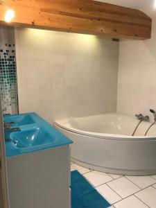 a bathroom with a white tub and a blue sink at Maison au coeur de l Auvergne pour 15 personnes in Mareugheol +11 photos