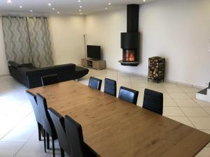 a room with a table and chairs and a fireplace at Maison au coeur de l Auvergne pour 15 personnes in Mareugheol