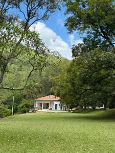 una casa in mezzo a un campo con alberi di Fazenda São Miguel a Monte Alegre do Sul
