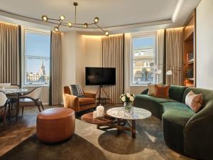 a living room with a green couch and a table at Corinthia London in London