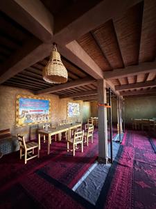 una sala da pranzo con un lungo tavolo e sedie di Desert Tours & Camp Chraika a M'Hamid