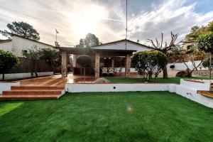 a house with a yard with green grass at HomeHolidaysRentals Confort in La Batlloria