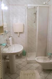 een witte badkamer met een wastafel en een douche bij Residence Piccola Oasi in Vigonza