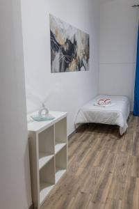 a white room with a bed and a desk at Borghetto Nora 3 in Gravina di Catania