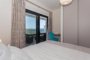 a bedroom with a bed and a large window at Villa Lemon Tree in Vinišće