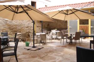 a patio with tables and chairs and umbrellas at Hotel Am Markt in Oebisfelde +22 photos