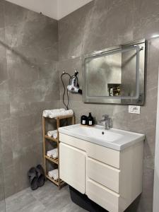 Un baño con un lavabo blanco y un espejo. en Hanna Apartment, en Tirana